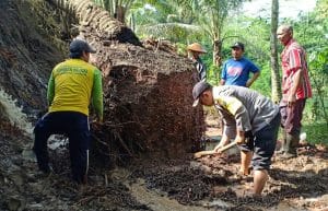 Bhabinkamtibmas Polsek Ngajum Bersama Warga Bersihkan Sisa Longsoran Tanah
