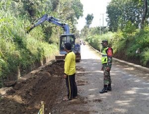 Dukung Pembangunan di Desa, Koramil 0818/29 Dau Dampingi Giat Pelebaran Jalan Dusun Ndoro