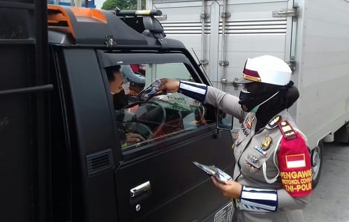 MASKER: Kasat Lantas AKP Diyana saat memberikan masker kepada masyarakat pengendara kendaraan bermotor.