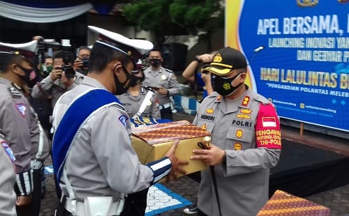 PENGHARGAAN: Kapores Malang AKBP Hendri saat memberikan piagam dan bingkisan kepada anggota Satlantas Polres Malang yang berprestasi dalam bidang layanan.