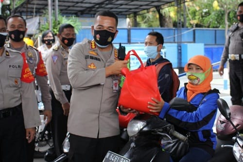 SEMBAKO: Kapolresta Malang Kota Kombes Pol Dr Leonardus membagikan sembako kepada pengendara difabel.