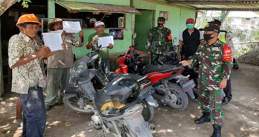 IMBAUAN: Anggota Koramil 01 Pujon saat melaksanakan imbaun kepada masyarakat yang tidak memakai masker.