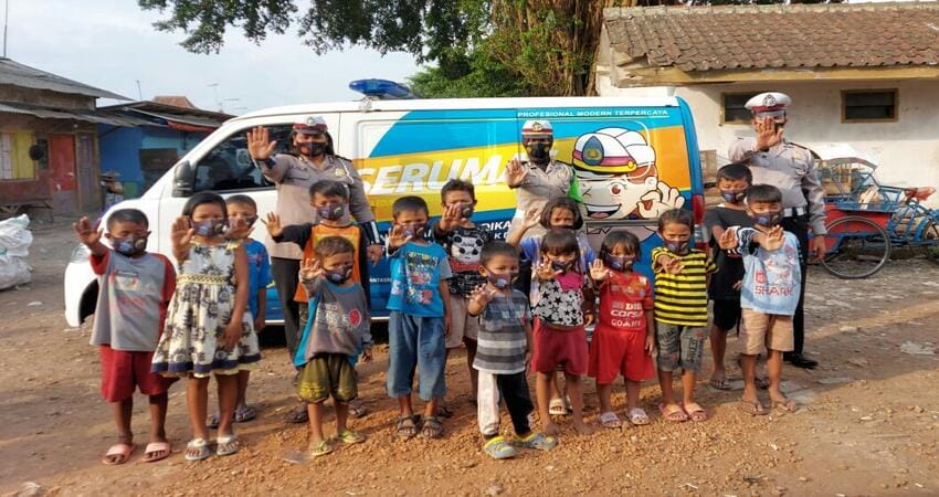 FOTO BERSAMA: Kanit Dikyasa Polres Malang Ipda Yulistiana bersama anggota Dikyasa lainnya saat berfoto bersama anak anak usia dini yang ada di pemukiman penampungan.