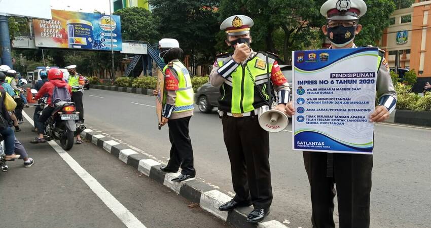IMBAUAN: Anggota Satlantas Polresta Malang Kota saat melaksanakan imbaun Protokol Covid-19 sesuai dengan Inpres No 6 tahun 2020.