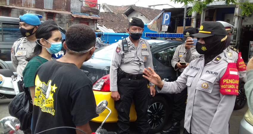 SANKSI: Pemberian sanksi kepada masyarakat yang tidak memakai masker oleh anggota Polsek Sukun.