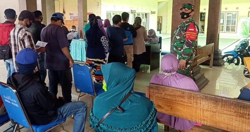 PENDAMPINGAN: Sertu Jainudin Babinsa Desa Ngijo Koramil 0818/28 Karangploso saat melaksanakan pendampingan penyaluran dana BST.