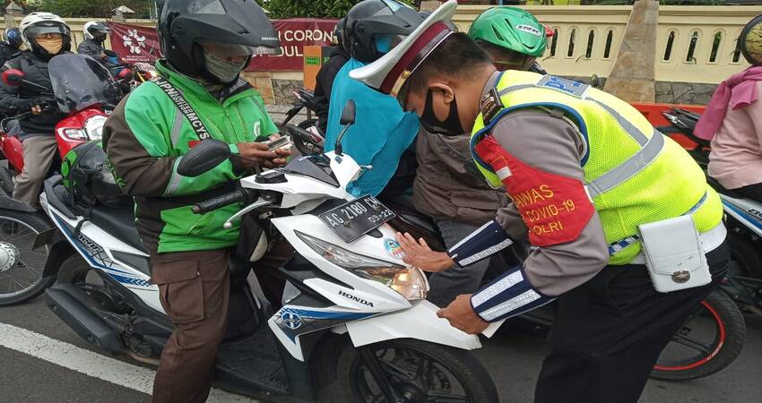 STIKER: Pemasangan stiker imbauan pemakaian masker kepada kendaraan bermotor roda dua.