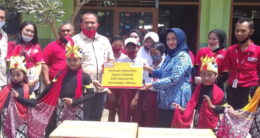 SIMBOLIS: Deputy Branch Manager Alfamart Malang, Daduk Budi Susilo secara simbolis memberikan bantuan 41 pasang sepatu sekolah ke Kepala Sekolah SDN 01 Sidorejo Ibu Kholifah.