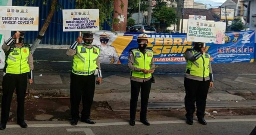 IMBAUAN: Anggota Satlantas Polres Malang saat melaksanakan sosialisasi Operasi Zebra Semeru 2020 dan imbauan Protokol Covid-19.