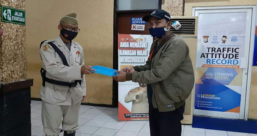 PEMOHON SIM: Petugas pelayanan Satpas SIM Polres Malang saat memberikan SIM dengan pakaian pahlawan kemerdekaan.