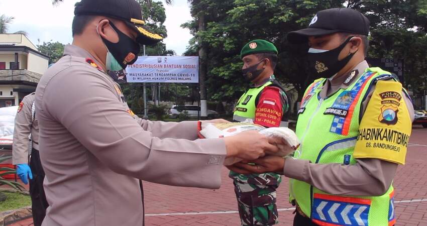 BANTUAN: Wakapolres Malang Kompol Toni Kasmiri secara simbolis menyerahkan bantuan beras kepada anggota Bhabinkamtibmas dan Babinsa.