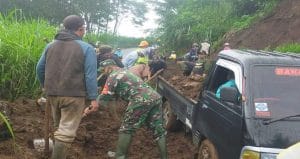 Anggota Koramil 0818/29 Dau Bersama Dinas Bina Marga Singkirkan Material Tanah Longsor di Desa Kucur