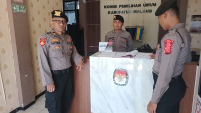 PENGUMUMAN: Anggota Polres Malang saat melaksanakan pengamanan kantor KPU jelang pendaftaran Paslon Pilkada 2024