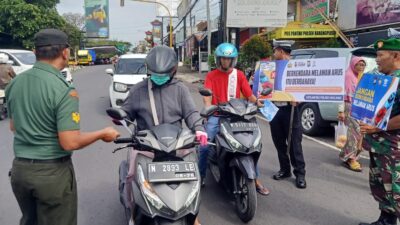 BROSUR: Satlantas Polres Malang bersama rekan TNI saat melaksanakan bagikan brosur himbauan tertib berlalu lintas